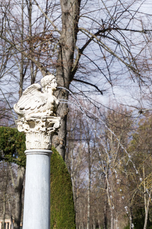 Close-up of medieval column with bird on top blowing water from female mouth and breastの写真素材