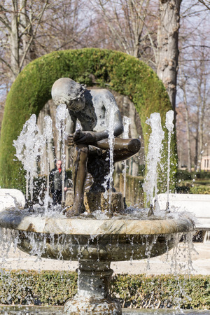 Medieval fountain with marble boy looking at his foot.Royal garden.の写真素材