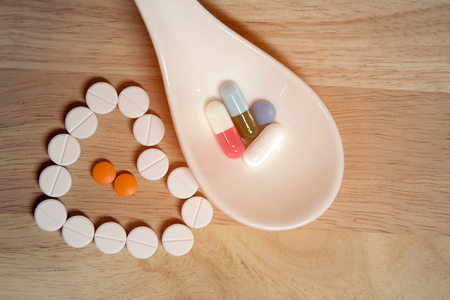 Tablets.Put on wooden floor.And put in a white spoon.Heart medicine.Beautiful arrangementの写真素材