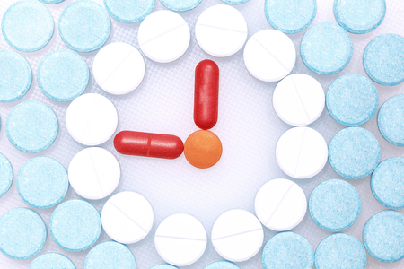 Catching a pill is a figurative figure.The pill is similar to the clock.の写真素材