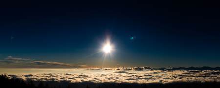 Sun setting into a sea of clouds, seen from stage 5 of Mt. Fuji.の写真素材