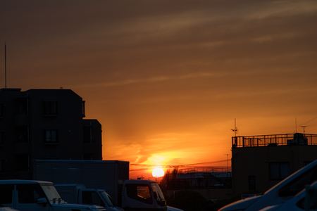 A sunset in an area of Tokyo with less skyscrapers. You can even see the silhouettes of the mountains in the distance.の写真素材
