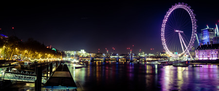 The London eye and the Thames river lit up at night.のeditorial素材
