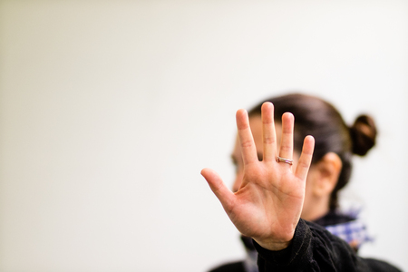 An engaged lady showing her palm to the camera, a clear sign of rejectionの写真素材