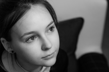 A portrait of a beautiful young woman looking up and away from the cameraの写真素材