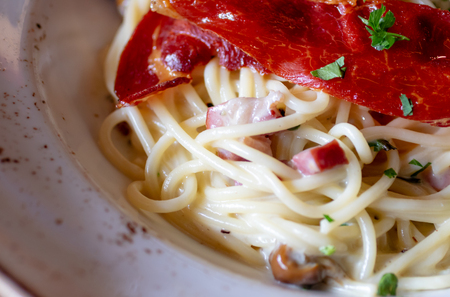 A close up shot of spaghetti carbonara with bacon.の写真素材