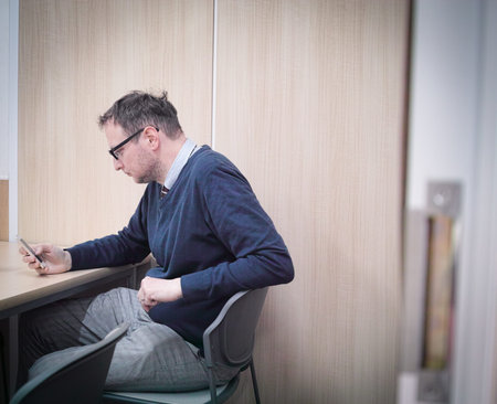 A man looking at his phone while killing time in his break.