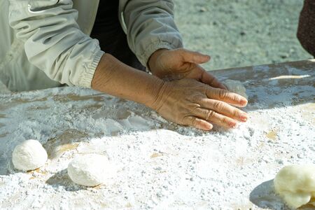 An older woman shaping mochi balls ready for the new yearの写真素材