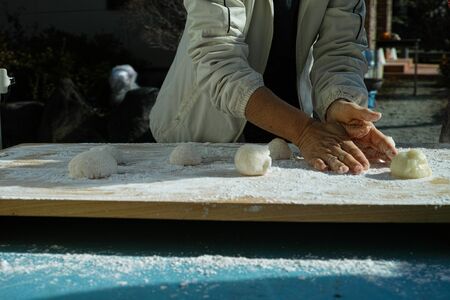 An older woman shaping mochi balls ready for the new yearの写真素材