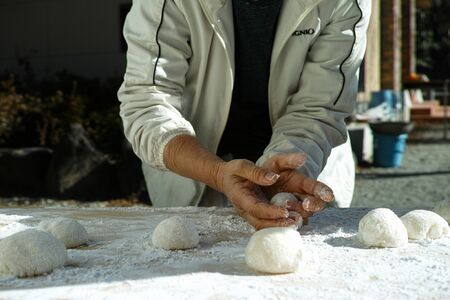An older woman shaping mochi balls ready for the new yearの写真素材