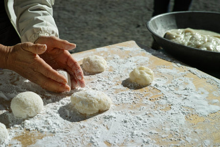 An older woman shaping mochi balls ready for the new year