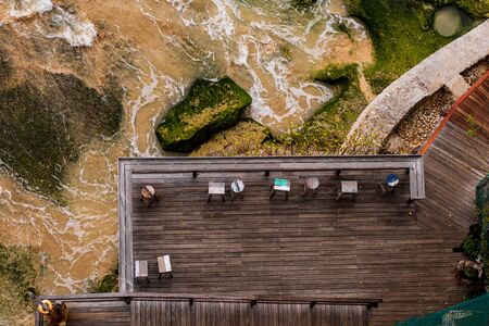 Aerial view of a decked seating area on a beach with a the sea coming in.の写真素材