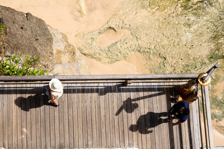 Aerial view of a decked seating area on a beach with a the sea coming in.