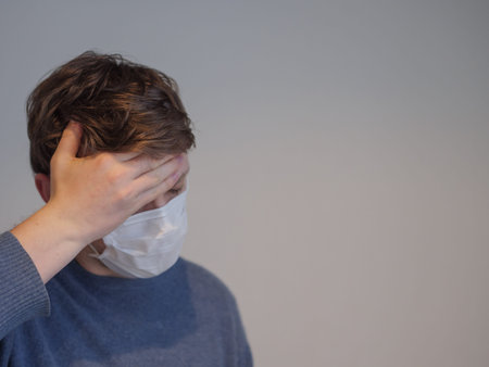 A young man with the flu checking his temperature
