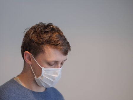 A sick young man wearing a maskの写真素材