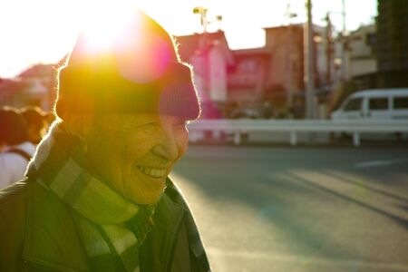 An old Asian man walking down the road in Winterの写真素材