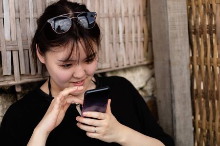 A young woman using her phone while relaxingの写真素材