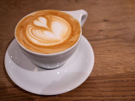 A coffee with a beautiful latte art heart on topの写真素材