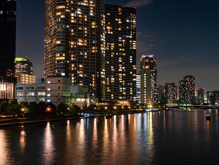 High rise buildings in Tokyo reflected in a riverの写真素材