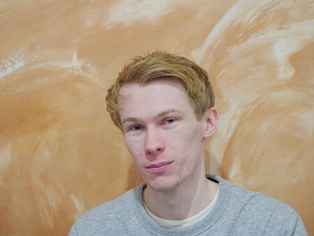 A man with a contented expression isolated on an orange backgroundの写真素材