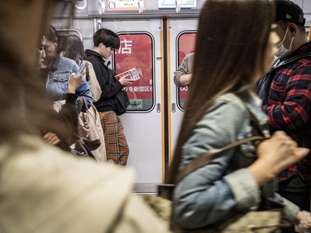 Tokyo, Japan - 10 11 19: people waiting to commute on a busy Tokyo train.
