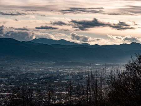 Sweeping views of a small Japanese town surrounded by mountainsの写真素材