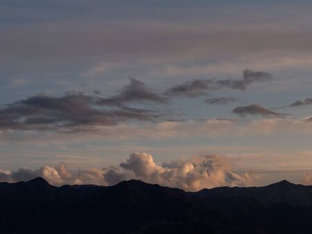 The tip of Mt. Fuji surrounded by clouds in the eveningの写真素材
