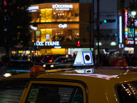 Shibuya, Japan - 7.2.20: A yellow cab pulled up in front of Shibuyas famous scramble crossing.のeditorial素材