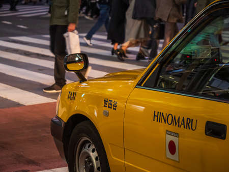 Shibuya, Japan - 7.2.20: A yellow cab pulled up in front of Shibuyas famous scramble crossing.のeditorial素材
