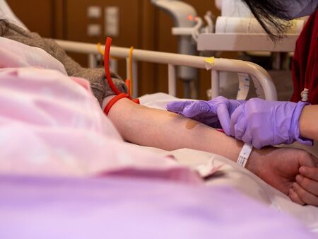 A nurse inserting a canula into a patients armの写真素材