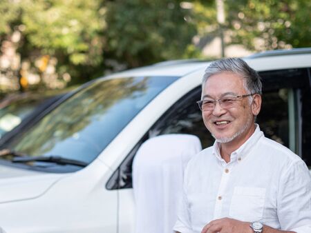 An older gentleman stood in front of his car looking smart.の写真素材