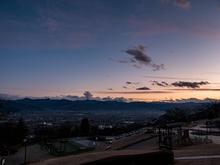 Views of Koufu city and the surrounding mountains at sunsetの写真素材