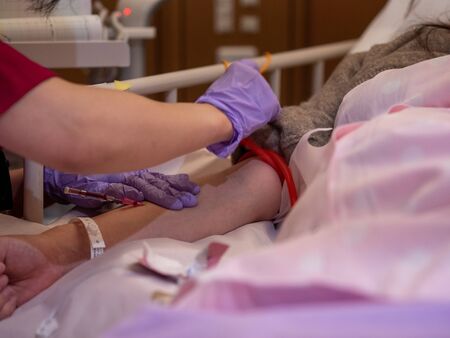 A nurse inserting a canula into a patients armの写真素材