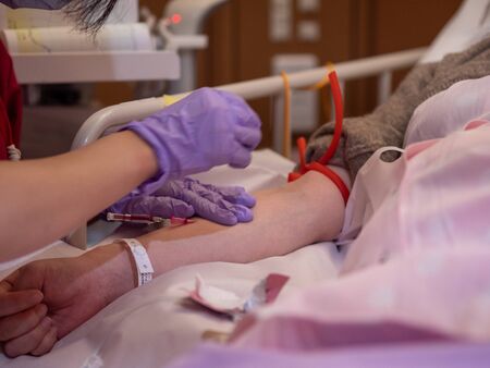 A nurse inserting a canula into a patients armの写真素材