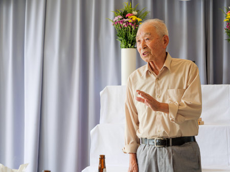 An elderly Asian man delivery a speech at a family event