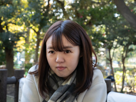 A Beautiful young Japanese woman looking coldの写真素材
