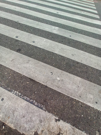 Crossing of road texture of pavement in perspective with white weathered paint