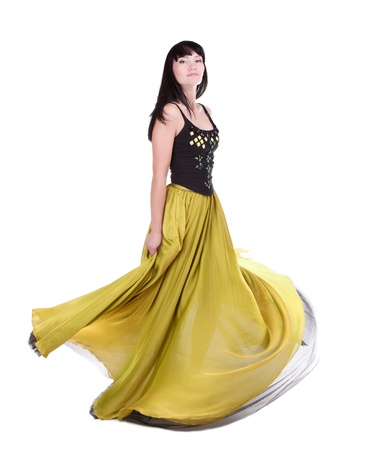 Beautiful woman twirling in her fashionable yellow-green colour dressの写真素材