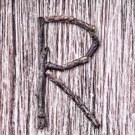 Latin capital alphabet letter R made from  sticks on vintage surfaceの写真素材