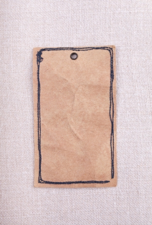 A vintage paper tag on fabric backgroundの写真素材