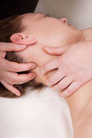A woman getting a stress relieving pressure point massage on her neck by a health therapistの写真素材