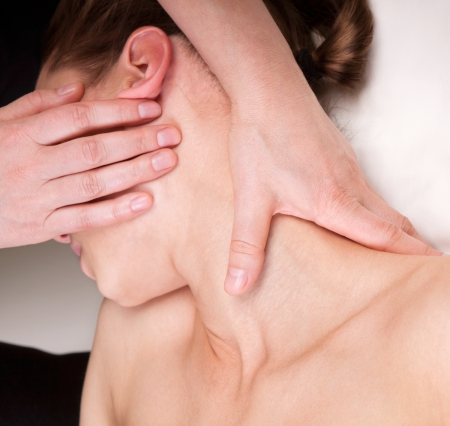 A woman getting relaxing massage on trapezius muscles of the neck by a qualified therapistの写真素材
