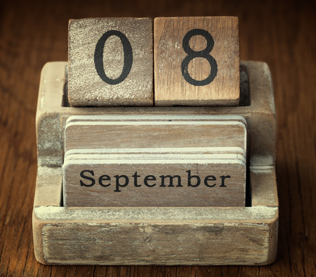 A very old wooden vintage calendar showing the date 8th September on wood backgroundの写真素材