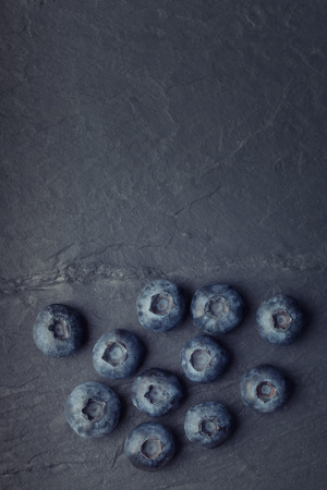 A bunch of delicious blueberries on a black vintage slate of tileの写真素材