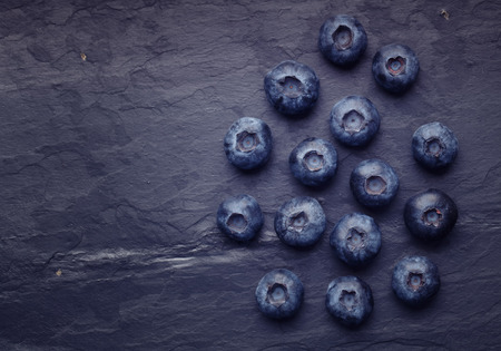 A bunch of delicious blueberry on slate of tileの写真素材