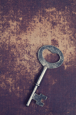 Old vintage key on shabby chic surfaceの写真素材