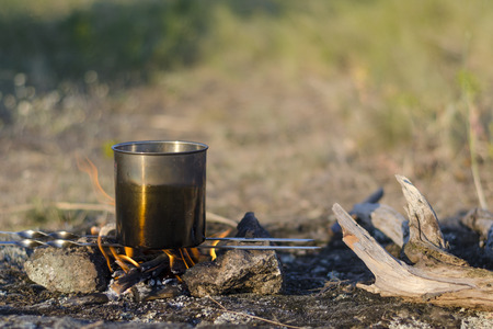 Bonfire while camping in the spring. At the stake water boils in the potの写真素材