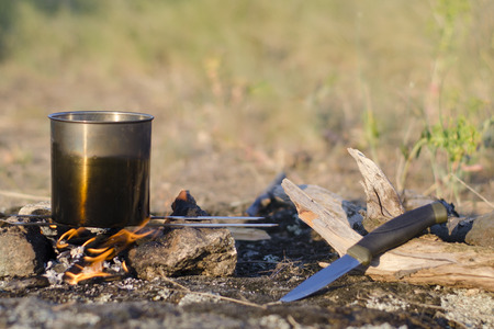 Bonfire while camping in the spring. At the stake water boils in the potの写真素材
