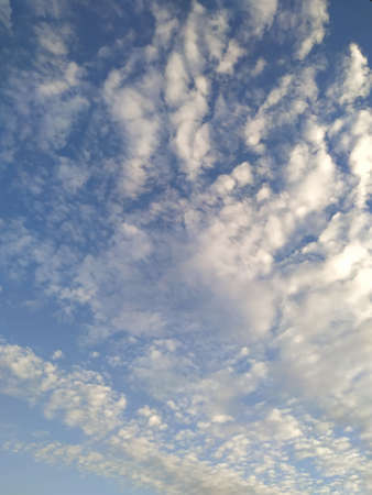 Bright blue sky background with fluffy clouds in the afternoon. Vertical view.の写真素材