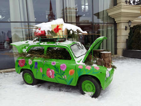 Christmas and New Year retro car with christmas tree and gifts on the snowの写真素材